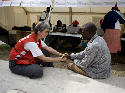 A humanitarian aid worker with the American Red Cross talks to a Haiti earthquake survivor