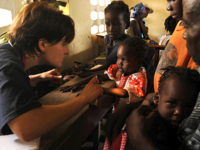An aid worker examines a kid in Haiti