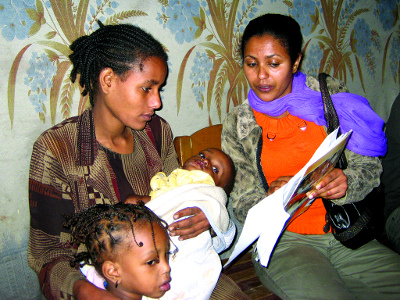 An aid worker interviews a mother