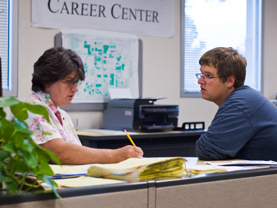 A recruitment coordinator at a career center speaks with a student about his resume