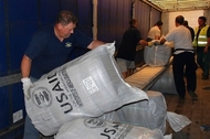 A man unloads USAID-donated wool blankets