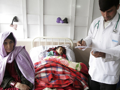 A health officer checks a patient's medical file at a hospital in Afghanistan